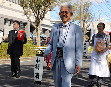 画像：リコーフレックスを首から下げて、行列行進中の太田さん