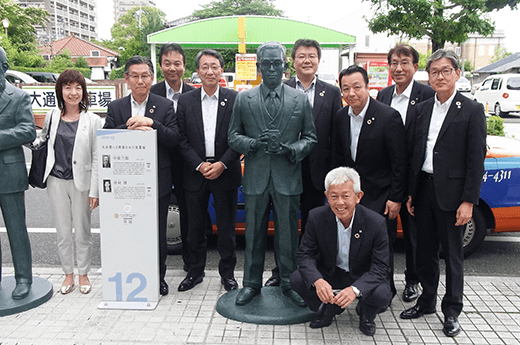 画像：佐賀の偉人として設置された市村清モニュメントの前で